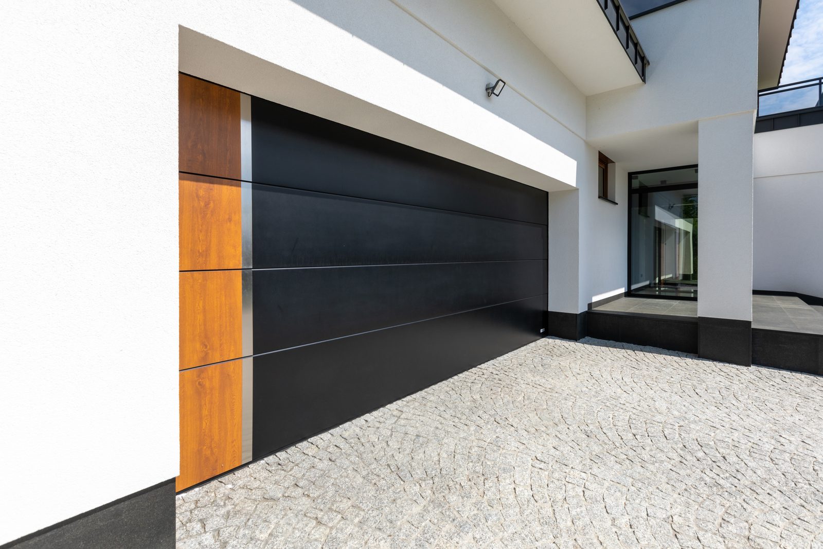 Dark sectional garage door with a wood-effect side panel
