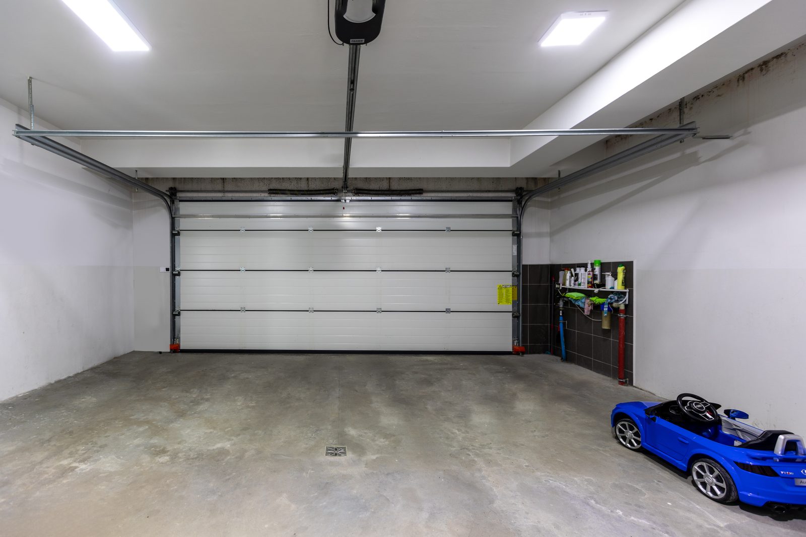 Inside a garage looking at a sectional door and its ceiling track